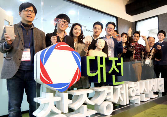 대전 카이스트(KAIST) 내 창조경제혁신센터에 입주해 있는 벤처 기업 임직원들이 지난달 30일 각 기업이 개발중인 아이디어 제품을 들어보이며 환하게 웃고 있다.  SK그룹 제공